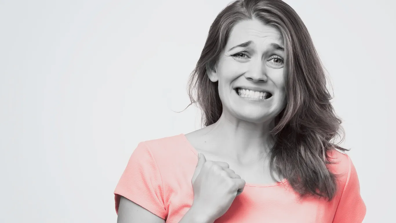 Woman cringing guiltily.