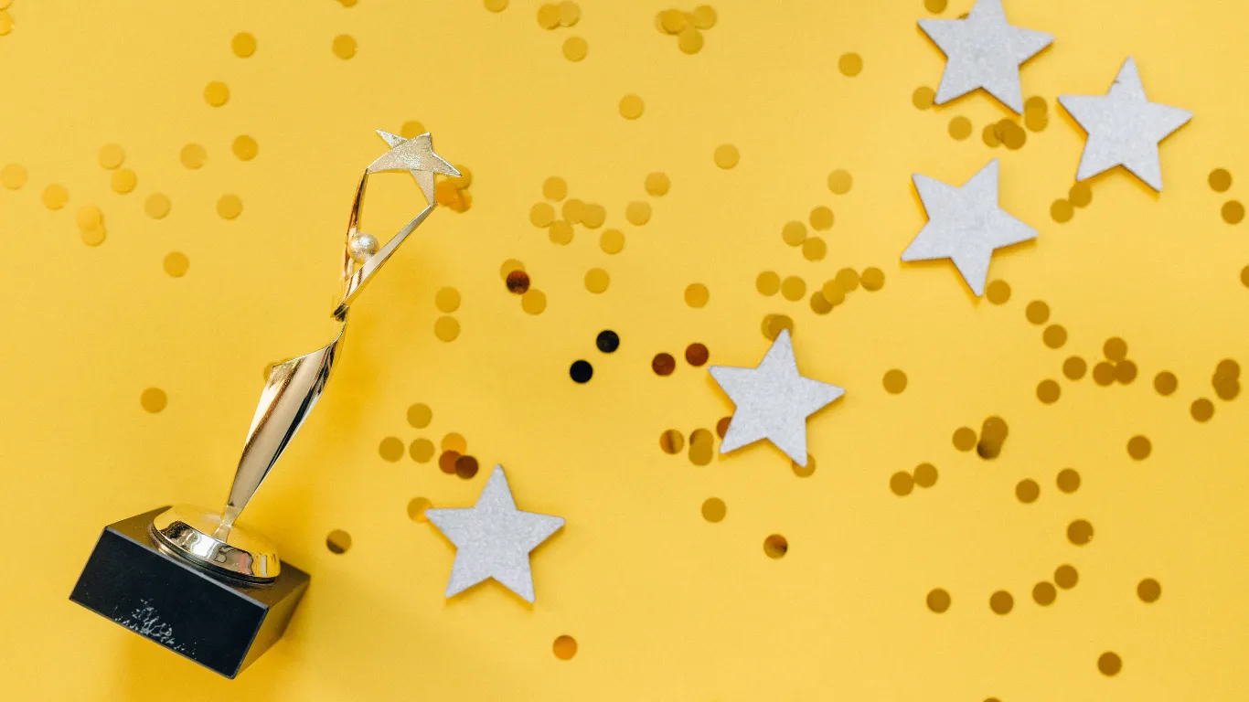 A trophy and confetti on a yellow background